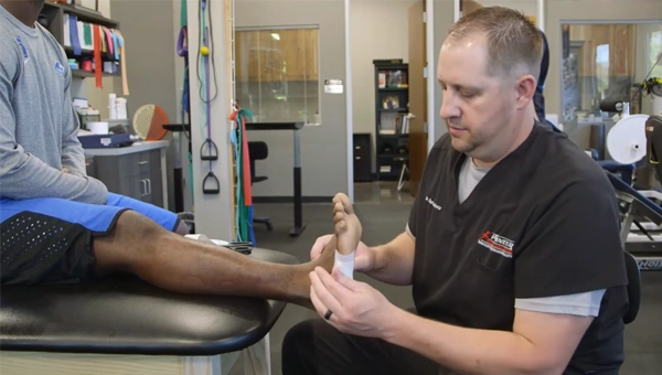 Dr. Kyle Burtenshaw performing a foot adjustment on a patient.